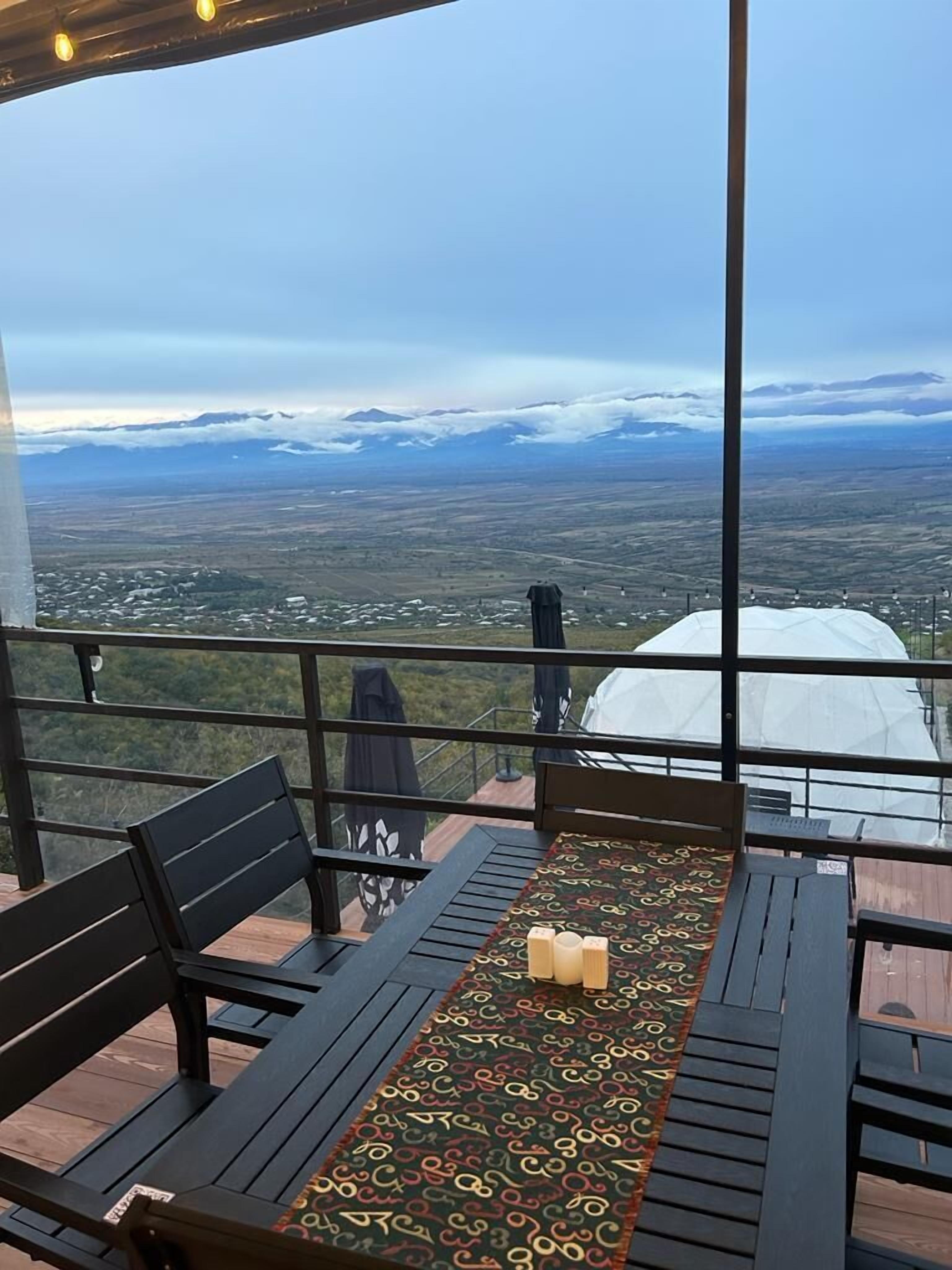 Ein Balkon mit Blick auf eine gebirgige Landschaft.