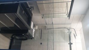 A modern bathroom with a glass shower enclosure, a black sink, and a toilet. - F2 Confortable, à 2 Minutes de la Plage et du Port (CARNON-PLAGE)