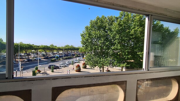 A view from inside a building looking out to a parking lot with cars and trees. - F2 Confortable, à 2 Minutes de la Plage et du Port (CARNON-PLAGE)