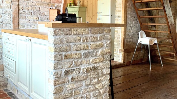 A rustic kitchen with a brick island, wooden beams, and a vintage refrigerator. - Cosy holiday home in Flanders Fields and at 10min from the sea. Pets welcome! (Alveringem)