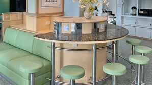 Uma cozinha moderna com um balcão verde, um mapa na parede e um vaso de flores.