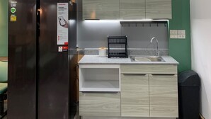 Uma cozinha compacta equipada com frigorífico, pia e armários.