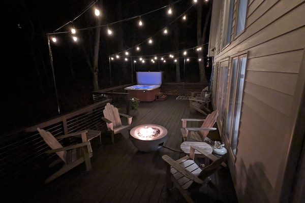 Large deck with salt water hot tub, firepit, dining area, and Weber gas grill.