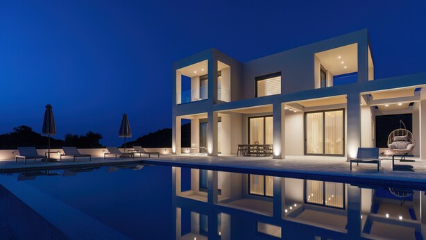 A modern two-story house with a swimming pool, outdoor seating, and large windows.
