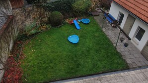 A courtyard with a green lawn, a blue slide, and a small pool. - Bright, newly renovated TOP flat in a central location (Osnabrück)
