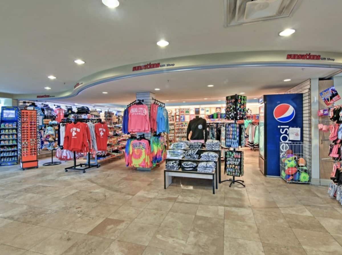 A gift shop with various merchandise including t-shirts, hats, and bags.