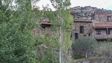 Un puente de piedra, edificios rústicos y un paisaje natural.