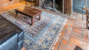 A traditional living room with a fireplace, a chandelier, and a large mirror on the wall. - El Mirador de las Jaras (Patones)