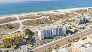 Et hotel med flere etager, parkeringsplads og udsigt til stranden.
