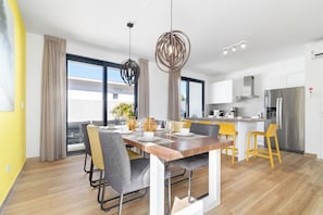 A modern kitchen with a stainless steel refrigerator, a built-in oven, and a microwave. - Beautiful 3BR Townhouse near Palm Beach (Noord)