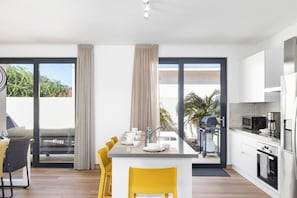A modern kitchen with a dining area, large windows, and a view of the outdoors. - Beautiful 3BR Townhouse near Palm Beach (Noord)