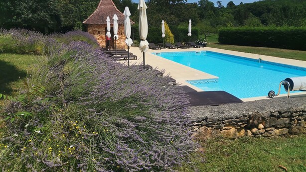 A swimming pool with a stone house and lounge chairs in the background. - Gite Tout Confort 4personnes Avec Piscine, Proche Lot, Dordogne, Lot et Garonne (Marminiac)