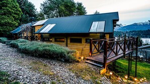 Eine Holzhütte mit Metall-Dach und einer Terrasse mit Geländern.