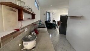 A kitchen with a stove, refrigerator, and dining area. - My place in paradise (Puerto Baquerizo Moreno)