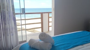 A hotel room with a bed, a view of the beach, and a balcony. - Las Fragatas Casa Hotel  (Canoas de Punta Sal)