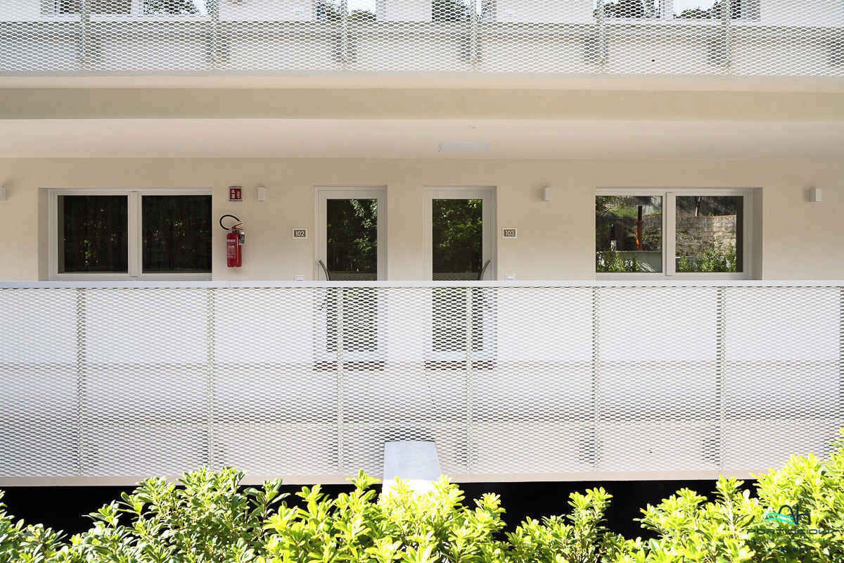 Ein mehrstöckiges Gebäude mit Balkon, Fenstern und einem Feuerlöscher.