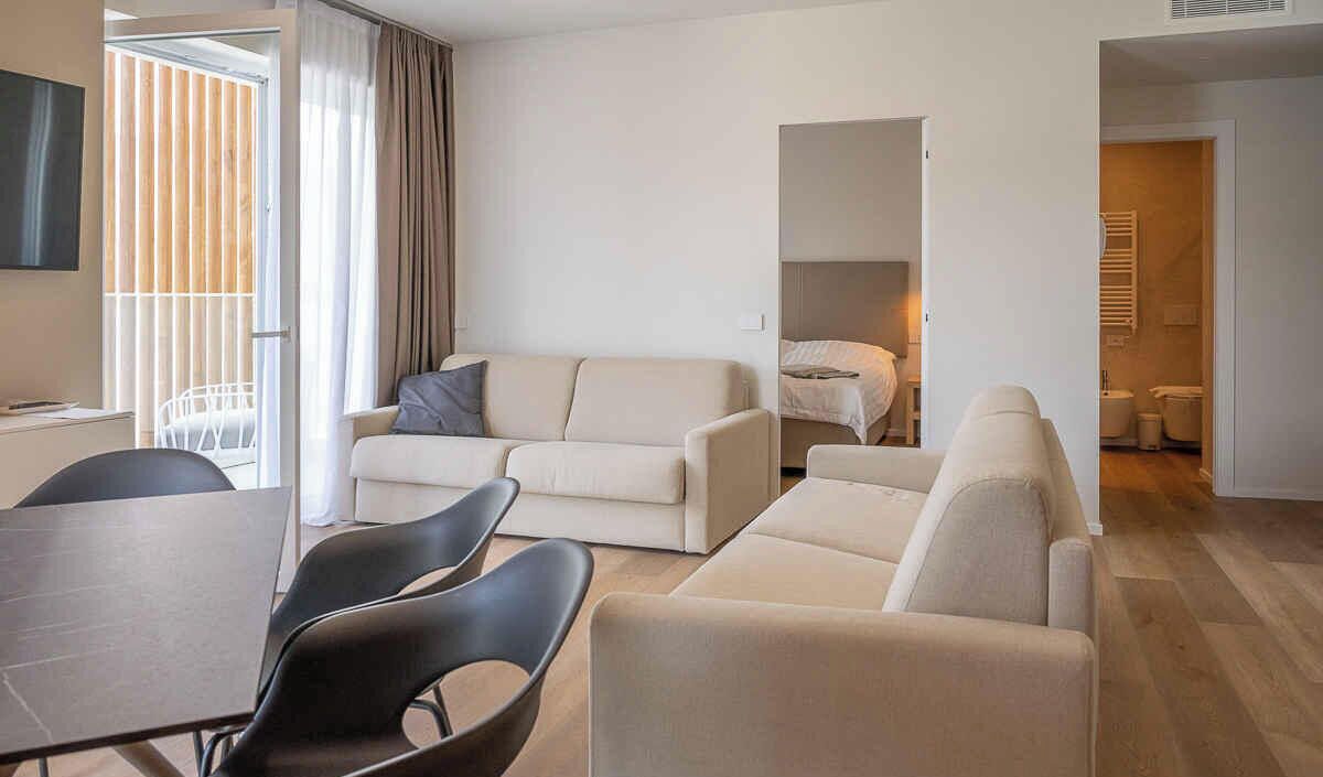 Un salon moderne avec un canapé, des fauteuils et une table à manger.
