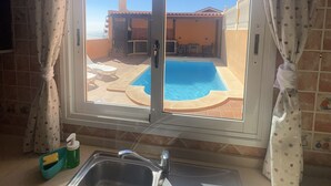 Una cucina con vista su una piscina e un patio.