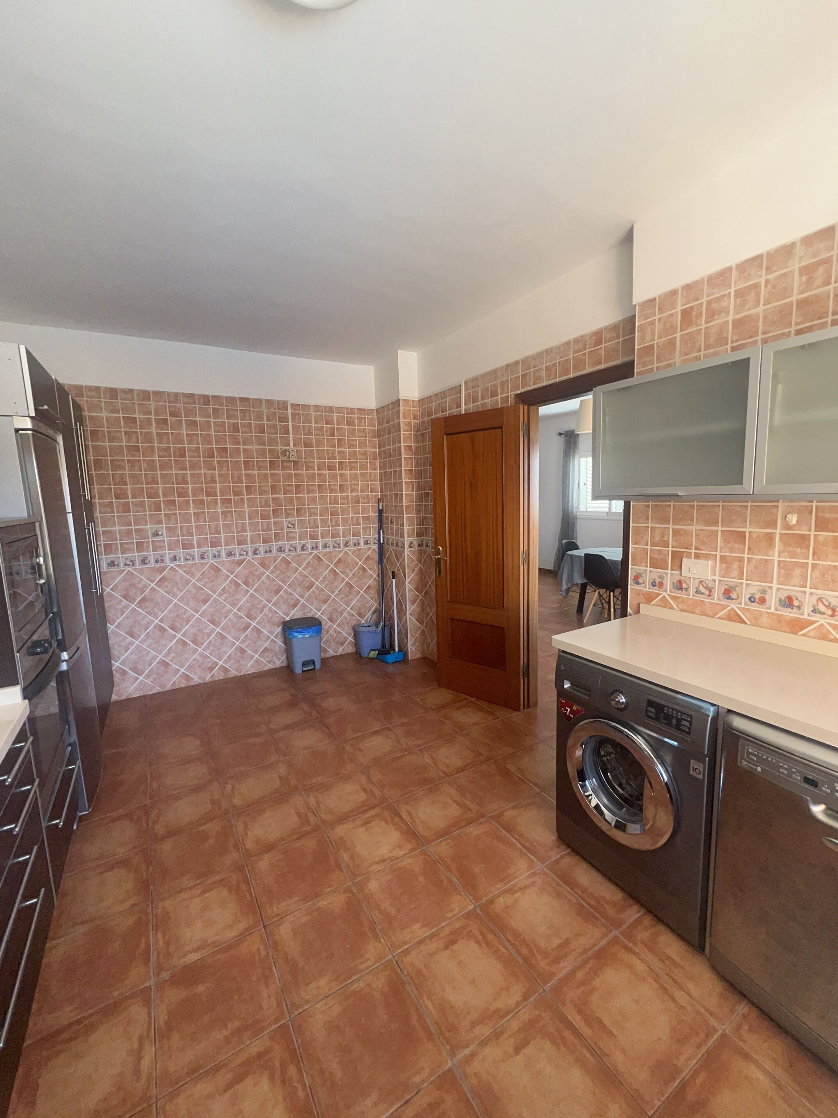 A kitchen with a washing machine, a microwave, and a stove.