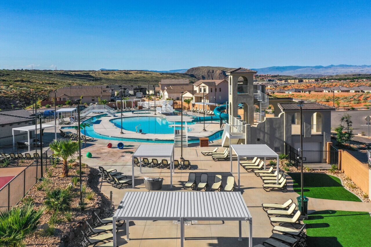 A resort with a large pool, sun loungers, and a bell tower.