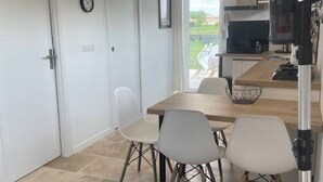 A compact kitchen with a wooden table and four white chairs.