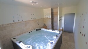 A bathroom with a large bathtub, a shower, and a toilet.