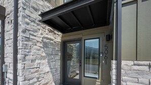 A stone facade with a door and window, number 506, and a small porch area. - Snowbasin Chalet R5061 |Ski Escape|Firepit |Hot Tub (Mountain Green)