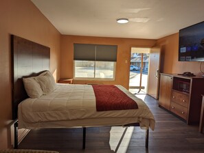 A bedroom with a bed, a window, a TV, and a kitchenette. - BEST WAY INN (Bridgeton)