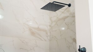 A shower with a modern design, a marble wall, and a door with a hook handle. - Enclave Villa V3 -Overlooking Pitons & Ocean ! Wow.  (Soufriere)
