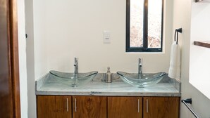 A bathroom with two glass sinks, wooden cabinets, a window, and a towel rack. - Enclave Villa V3 -Overlooking Pitons & Ocean ! Wow.  (Soufriere)
