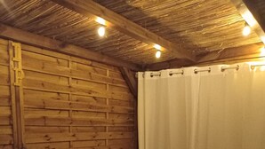 A hot tub in a wooden room with a brick wall and a white curtain. - Bienvenue à la Maison D'hôtes L'instant Present (Le Moule)