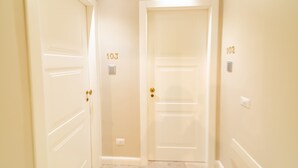 A hallway with two white doors, each marked with a number. - B&Bio Architiello (Naples)