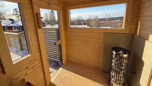 A wooden cabin with a view of a snowy landscape through large windows. - Modern Cabin (Västra Götalands län)