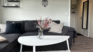 A modern living room with a sectional sofa, a white coffee table, and a decorative deer head on the wall. - Modern Cabin (Västra Götalands län)
