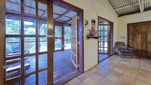 Un pasillo con puertas de madera, una silla y suelo de baldosas.