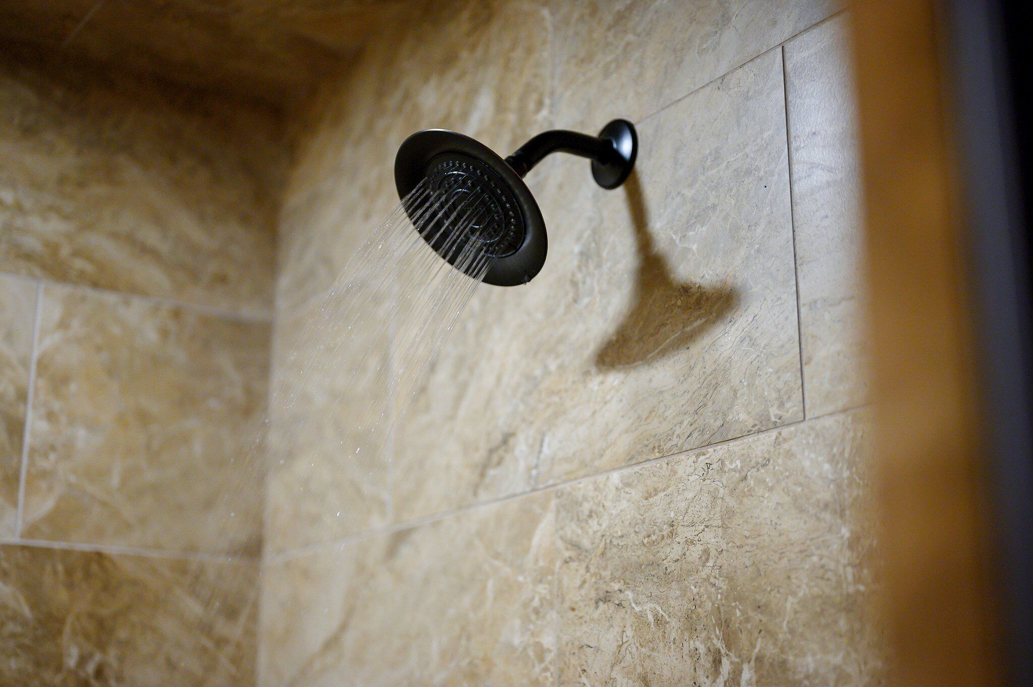 Un cabezal de ducha instalado en una pared con azulejos.