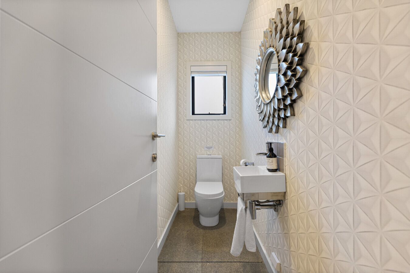 Une salle de bain équipée de toilettes, d’un lavabo et d’un miroir décoratif.