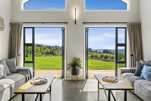 A seating area seamlessly extends from the kitchen under expansive gable ceilings, filling the space with abundant natural light.