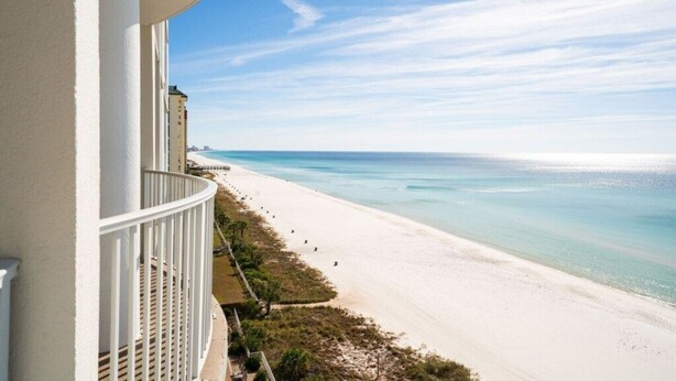 Ein Balkon mit Blick auf Strand und Meer.