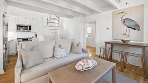 Una sala moderna con un sofá, una mesa de centro y un cuadro de un pájaro.