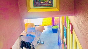 A staircase with a colorful mural, a bicycle, and a potted plant. - Room-central Comfy Small Studio (San Cristóbal de las Casas)