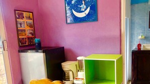 A small kitchenette with a refrigerator, a coffee maker, and a green cabinet. - Room-central Comfy Small Studio (San Cristóbal de las Casas)