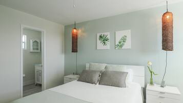 Un dormitorio moderno con cama, mesitas de noche y mesilla.