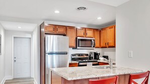 Una cocina moderna con armarios de madera, electrodomésticos de acero inoxidable y encimera de granito.