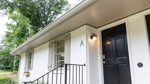 A white building with a black door and a small porch with a black railing. - Artist's Bungalow- 1/2 mi from Covington Square (Covington)