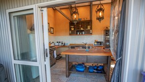 A compact kitchen with a wooden countertop, built-in cabinets, and a hanging light fixture.