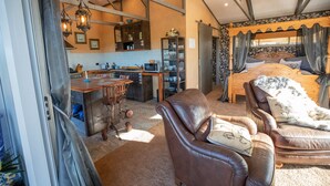A spacious room with a large bed, a dining area, and a kitchen.
