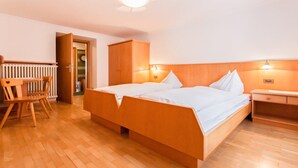 Ein Hotelzimmer mit zwei Betten, Holzmöbeln und einer Heizung.