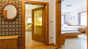 Ein Hotelzimmer mit einem hölzernen Bett, einem großen Spiegel und einer Wand mit Muster.