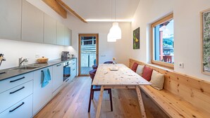Una cocina moderna con un banco de madera, una mesa de comedor y vistas al exterior.